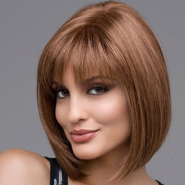 headshot of model wearing brown chin length wig with bangs