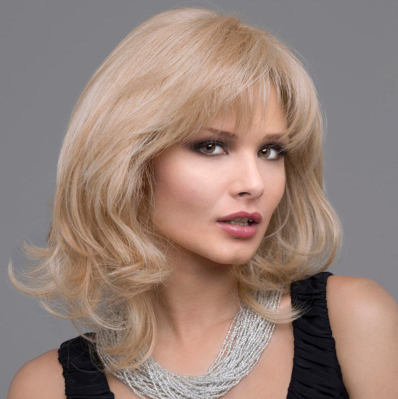 headshot of model wearing blonde shoulder length wig