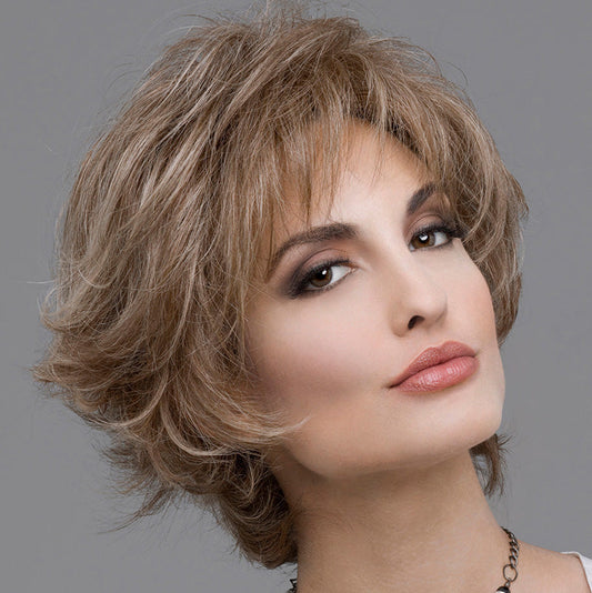 headshot of model wearing light brown spiky style wig