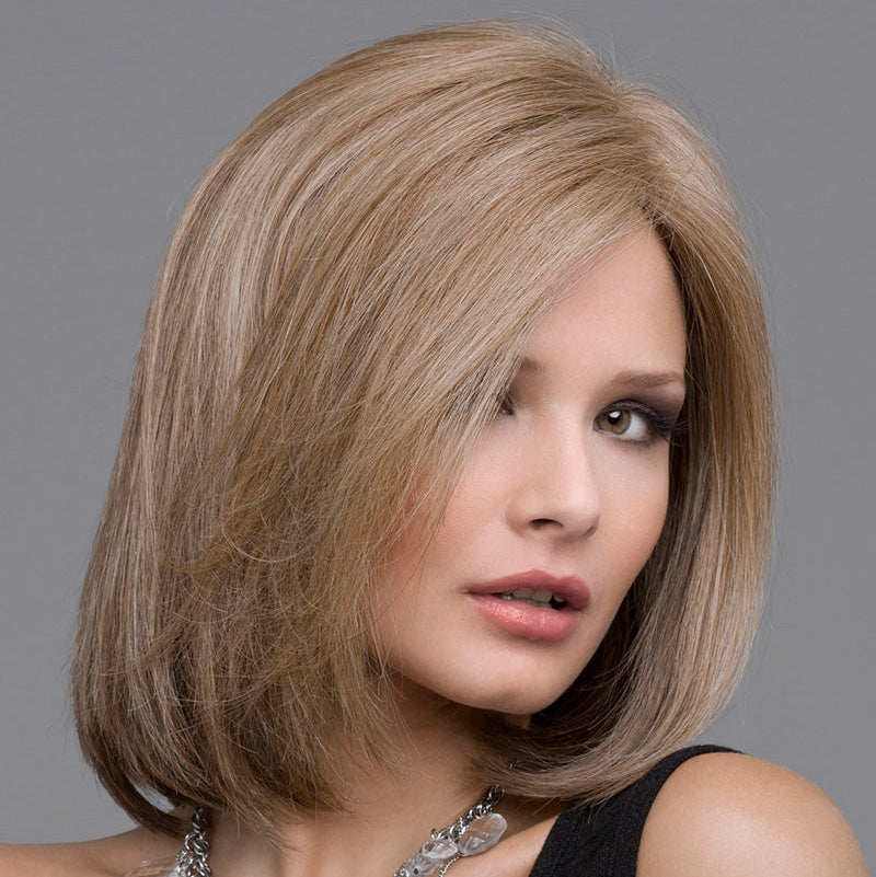 headshot of model wearing light brown bob style wig