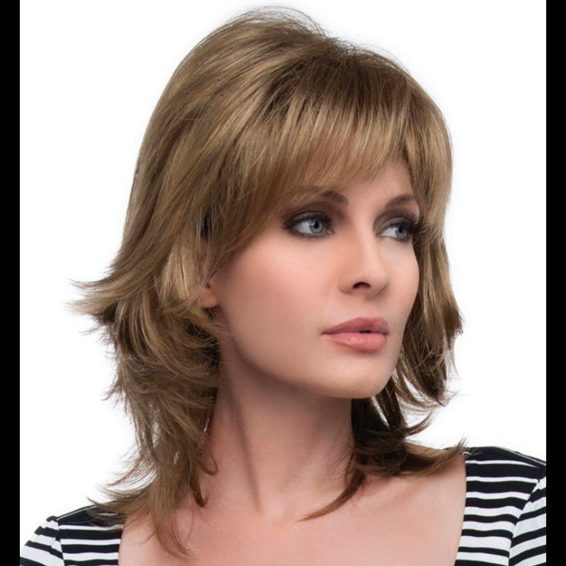 headshot of model wearing shoulder length layered wig with bangs