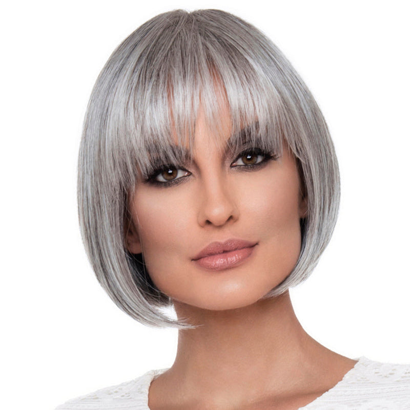 Headshot of model wearing grey bob style wig with bangs